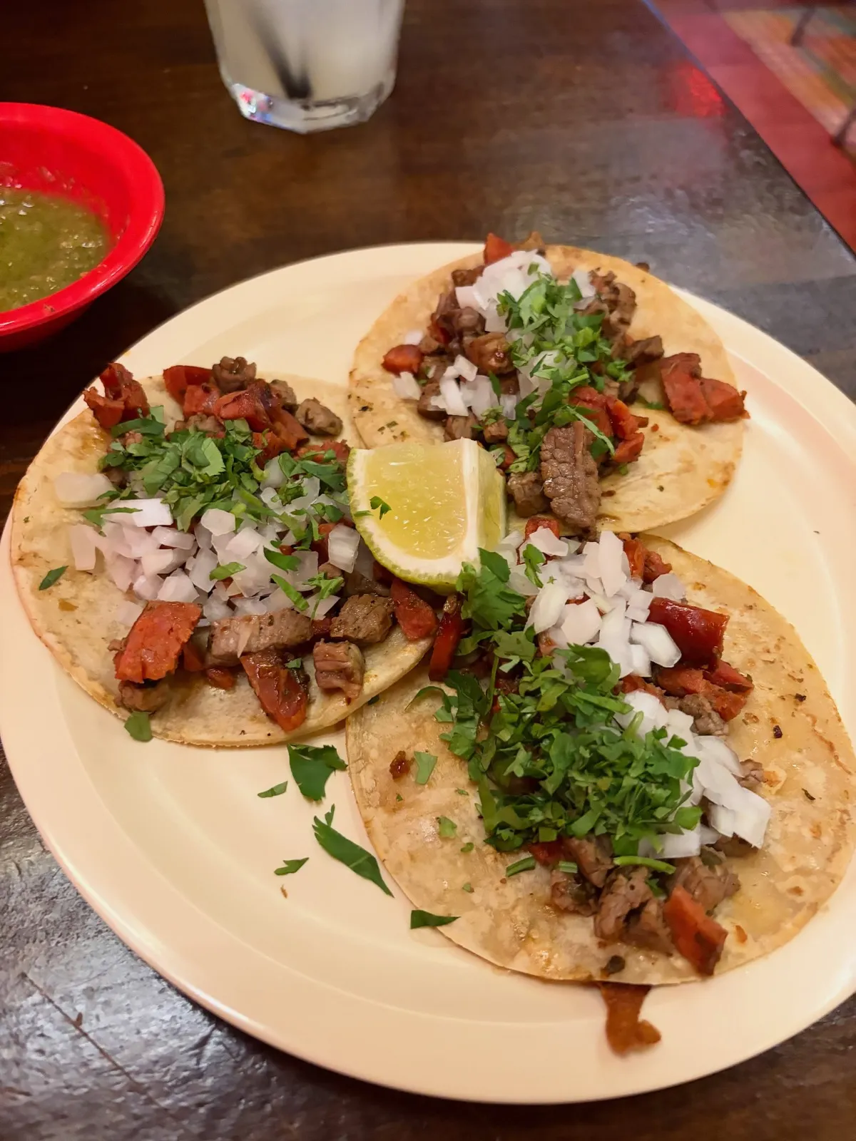 Una orden de tacos con cebolla, cilantro y limón